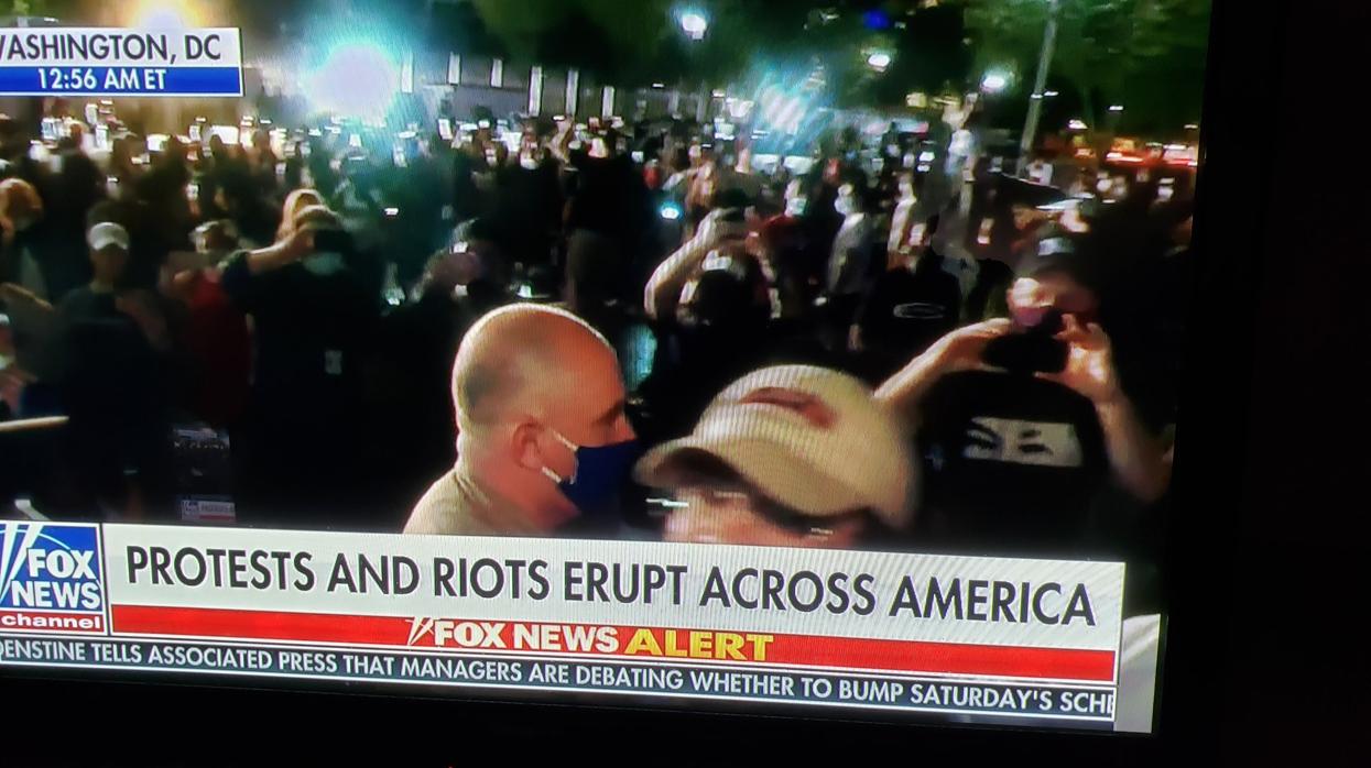 Captura de pantalla de una transmisión del canal FOX de un manifestante que viste una camiseta con los ojos de Chávez en una protesta en Washington