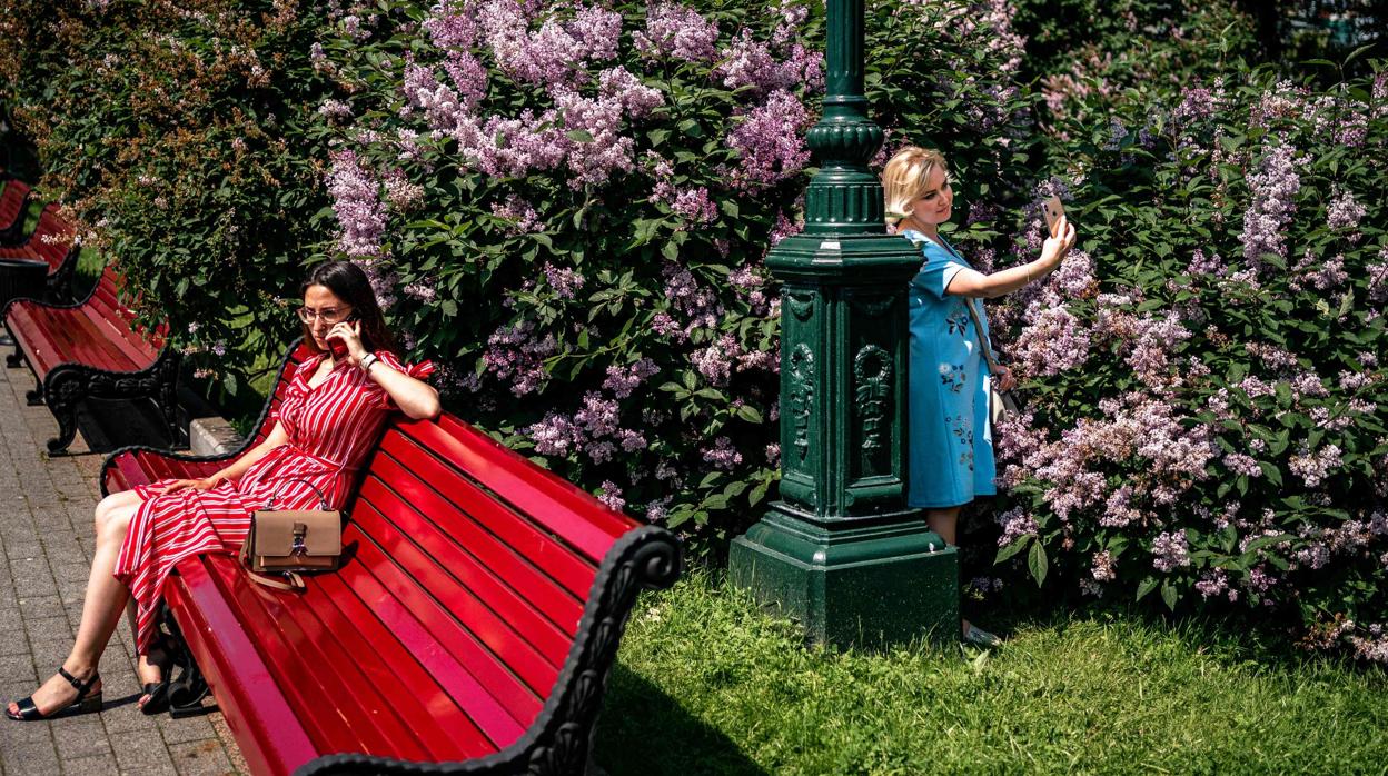 Dos mujeres rusas disfrutan del desconfinamiento en un parque de Moscú