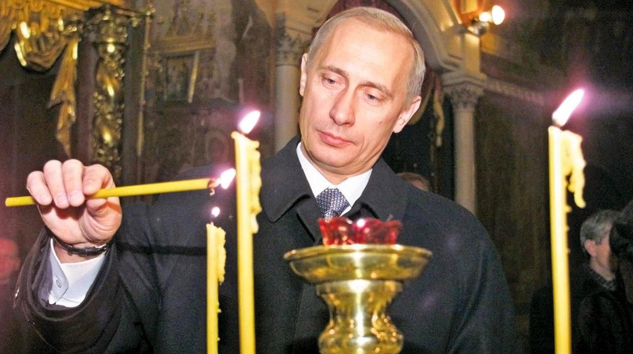 El presidente de Rusia, Vladímir Putin, encendiendo una vela en una catedral ortodoxa en el año 2000