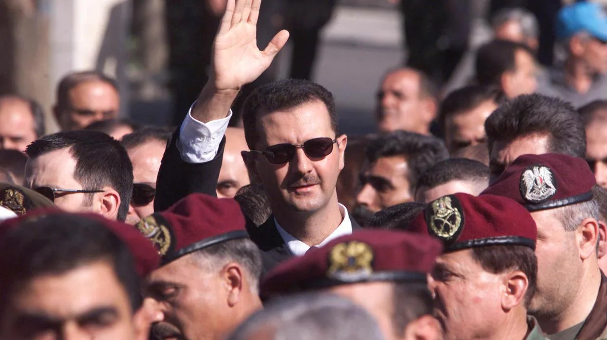 Bashar al Assad saluda a sus partidarios mientras marcha detrás del ataúd de su padre, el presidente sirio Hafez al-Assad, durante su funeral en Damasco