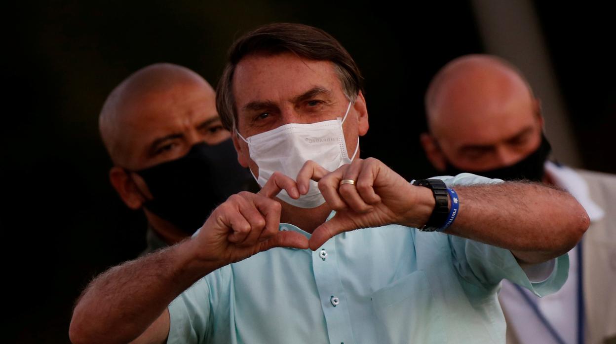 Bolsonaro hace gestos mientras se reúne con sus partidarios durante una ceremonia por los fallecidos por el coronavirus