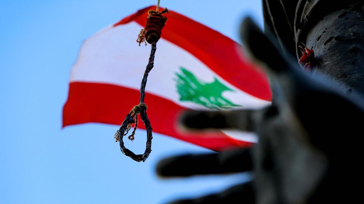 Un manifestante enarbola una bandera de Libano frente a los agentes antidisturbios el pasado sábado/ VÍDEO: Vistas del puerto de Beirut desde una embarcación