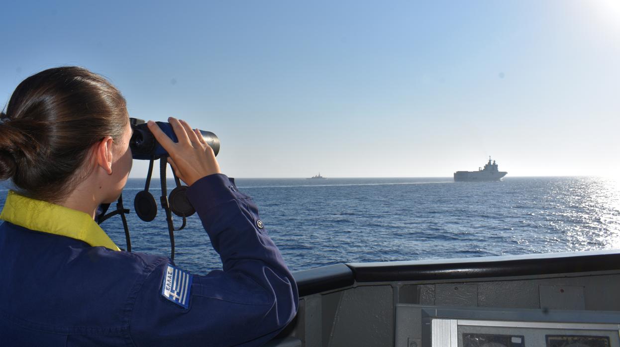 Una mujer observa durante unos ejercicios militares conjuntos de Grecia y Francia en el Mediterráneo