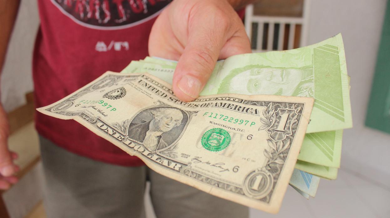 Una persona muestra bolívares y dólares el 14 de agosto de 2020 en San Cristóbal, Táchira (Venezuela)