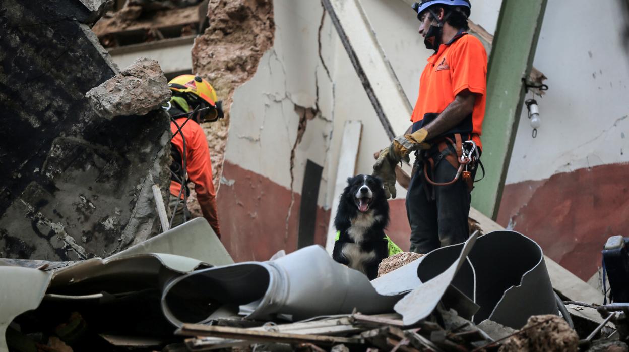 Flash busca entre los escombros de un edificio destruido por la explosicón alguna señal de vida