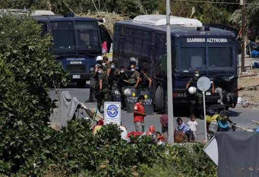 Vehículos de la policia pendientes de trasladar refugiados al nuevo campo