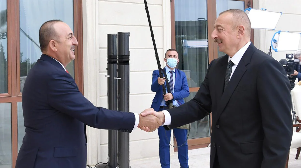 El ministro de Exteriores turco, Mevlut Cavusoglu (izquierda), saluda ayer al presidente de Azerbaiyán, Ilham Alíev, en una reunión en Baku
