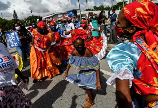 Haitiano-estadounidenses danzan durante la visita de Joe Biden a Miami