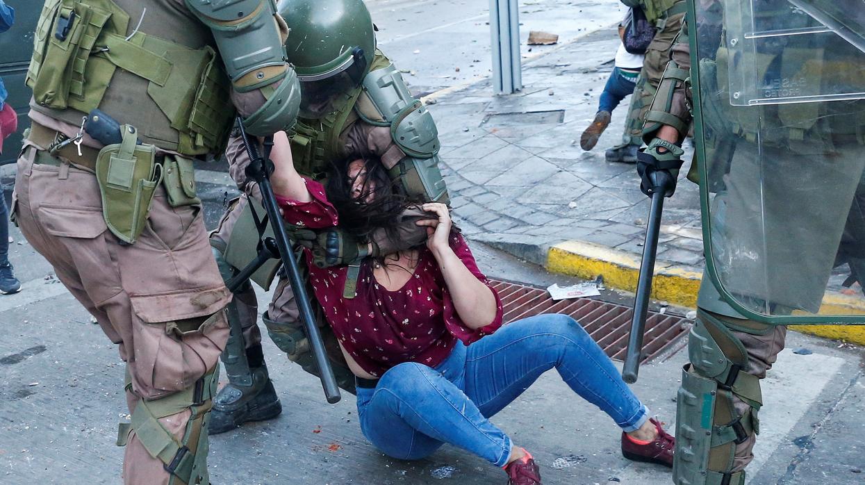 Una manifestante es detenida por la policía durante una protesta en Valparaíso