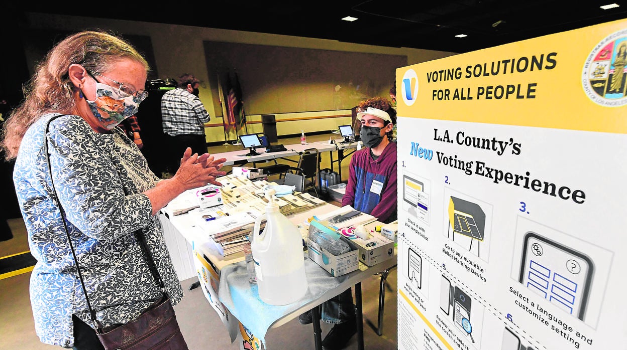 Una mujer se lava las manos a su entrada a un centro de votación en el condado de Los Ángeles, en California
