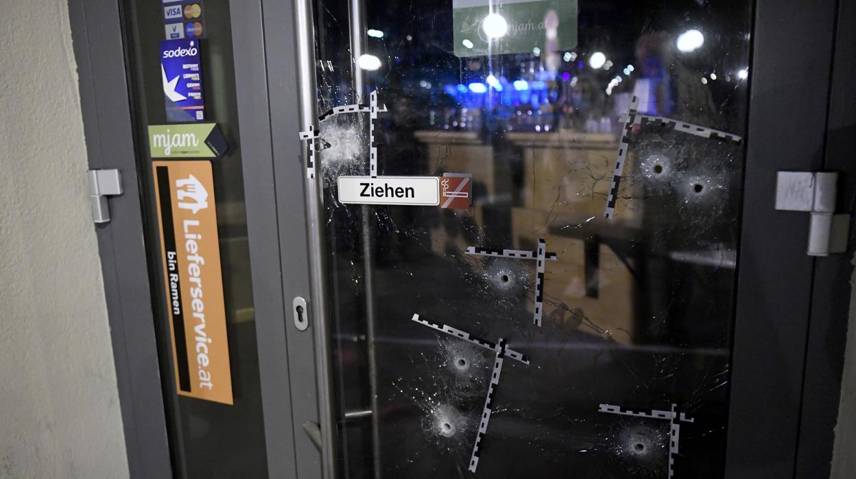 En la imagen se pueden apreciar los agujeros de bala en la puerta de un restaurante en el centro de Viena