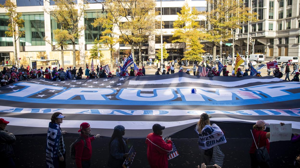 Simpatizantes de Trump, durante la marcha celebrada este sábado en Washington portan una bandera gigante con el nombre de Trump