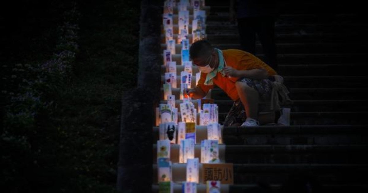 Un voluntario enciende una linterna con un mensaje de paz en el Parque de la Paz en Nagasaki durante el 75 aniversario del bombardeo atómico de 1945