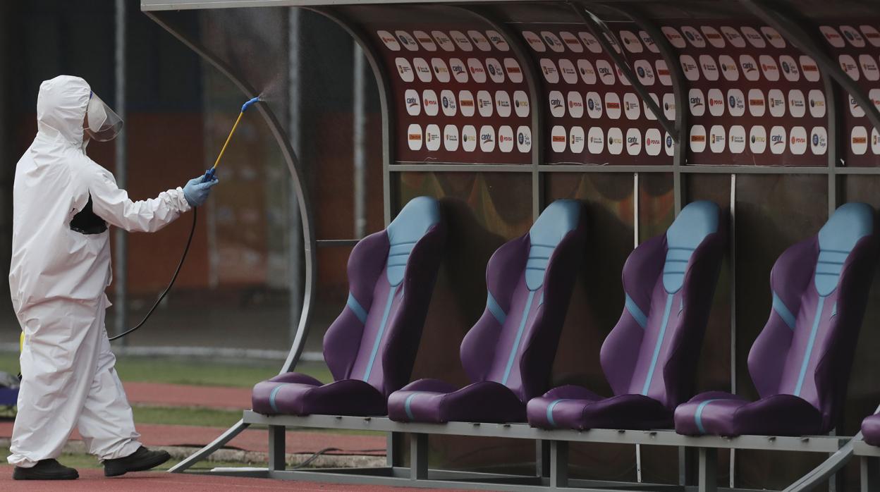 Un hombre desinfecta un estadio de fútbol en Caracas para combatir la pandemia