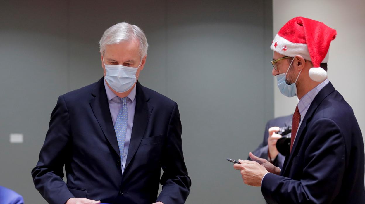 Barnier con un ejemplar del acuerdo, junto al embajador griego, en la reunión del Coreper