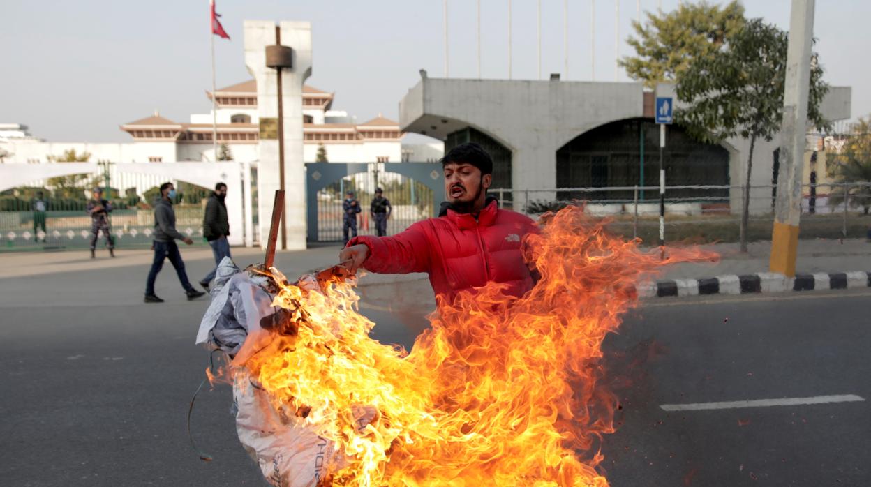 Un manifestante quema una efigie del primer ministro de Nepal, en los alrededores del su Parlamento del país