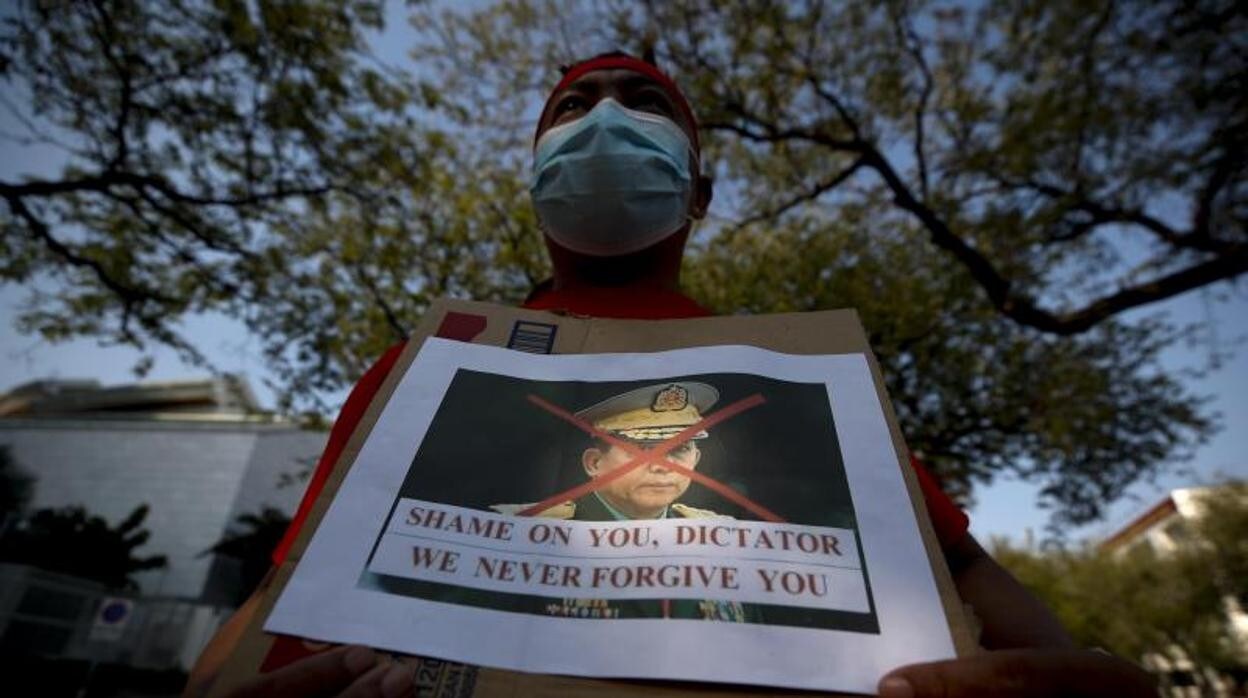 Un manifestante en Myanmar sostiene una foto desfigurada del jefe de la junta militar durante una protesta contra el golpe de Estado militar
