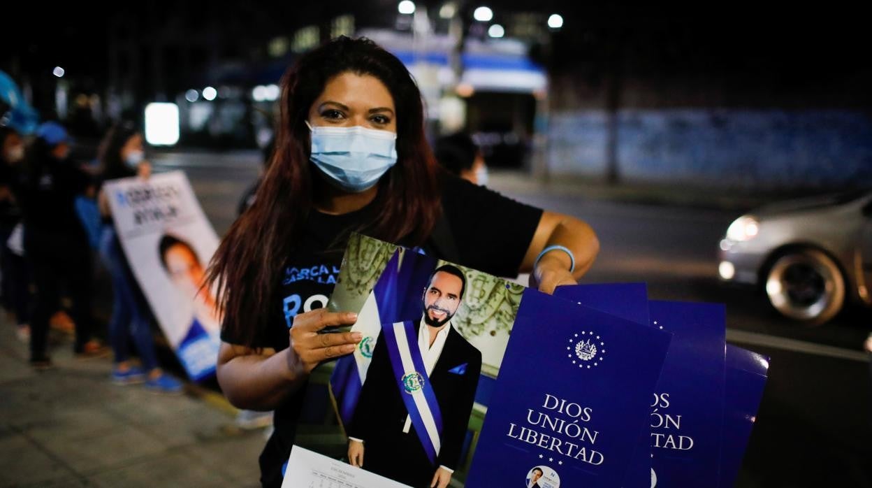 Una simpatizante del partido de Bukele sostiene un calendario con una fotografía del presidente