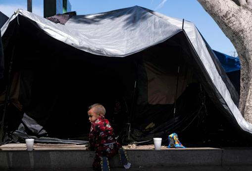 Un niño inmigrante junto a una de las tiendas del campamento El Chaparral