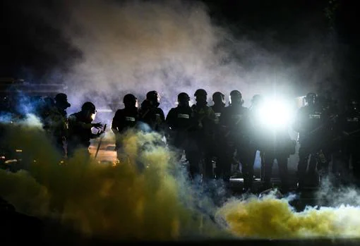 La policía antimotines en una nube de gas lacrimógeno