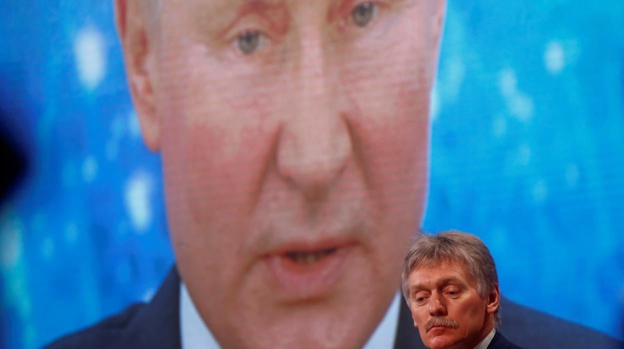 El portavoz de la Presidencia rusa, Dmitri Peskov, frente a una pantalla electrónica en la que comparece Putin