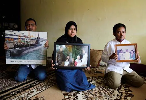 Familiares de los desaparecidos en el submarino muestran fotos de los desaparecidos