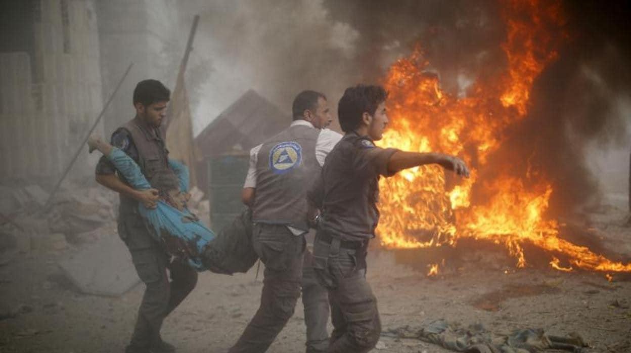 El personal de emergencia sirio lleva a un hombre herido tras los ataques aéreos de las fuerzas del gobierno