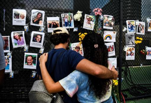 Una pareja observa fotos de víctimas de la tragedia de Miami