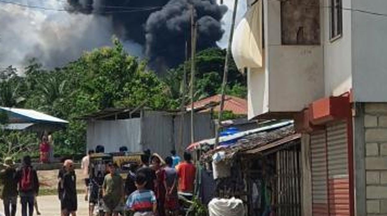 Residentes observan el humo tras el accidente de un avión de transporte Lockheed C-130 de la Fuerza Aérea de Filipinas