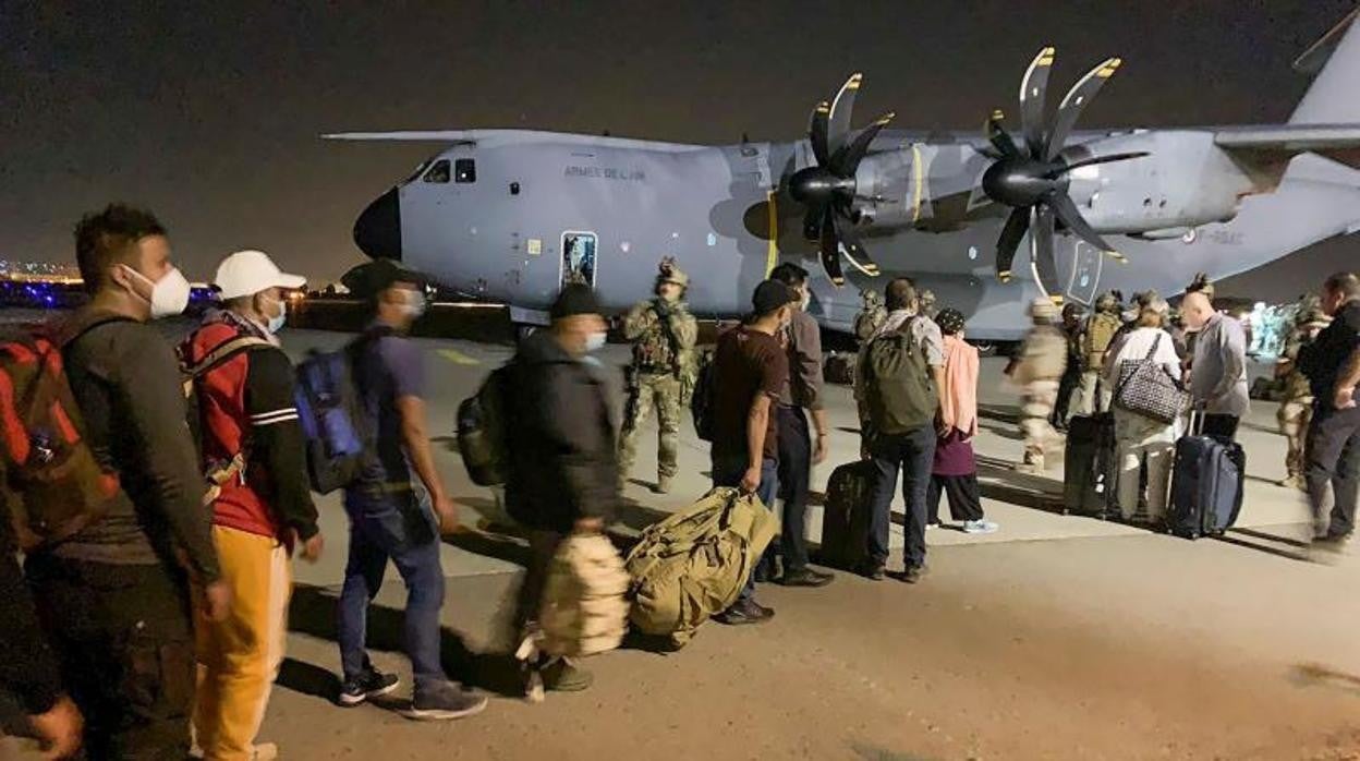 Ciudadanos franceses y afganos suben a un avión de transporte militar francés en el aeropuerto de Kabul