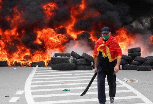 Un manifestante junto a la barricada