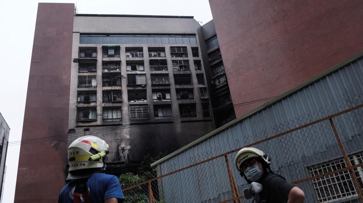 Los bomberos miran cómo ha quedado el edificio incendiado