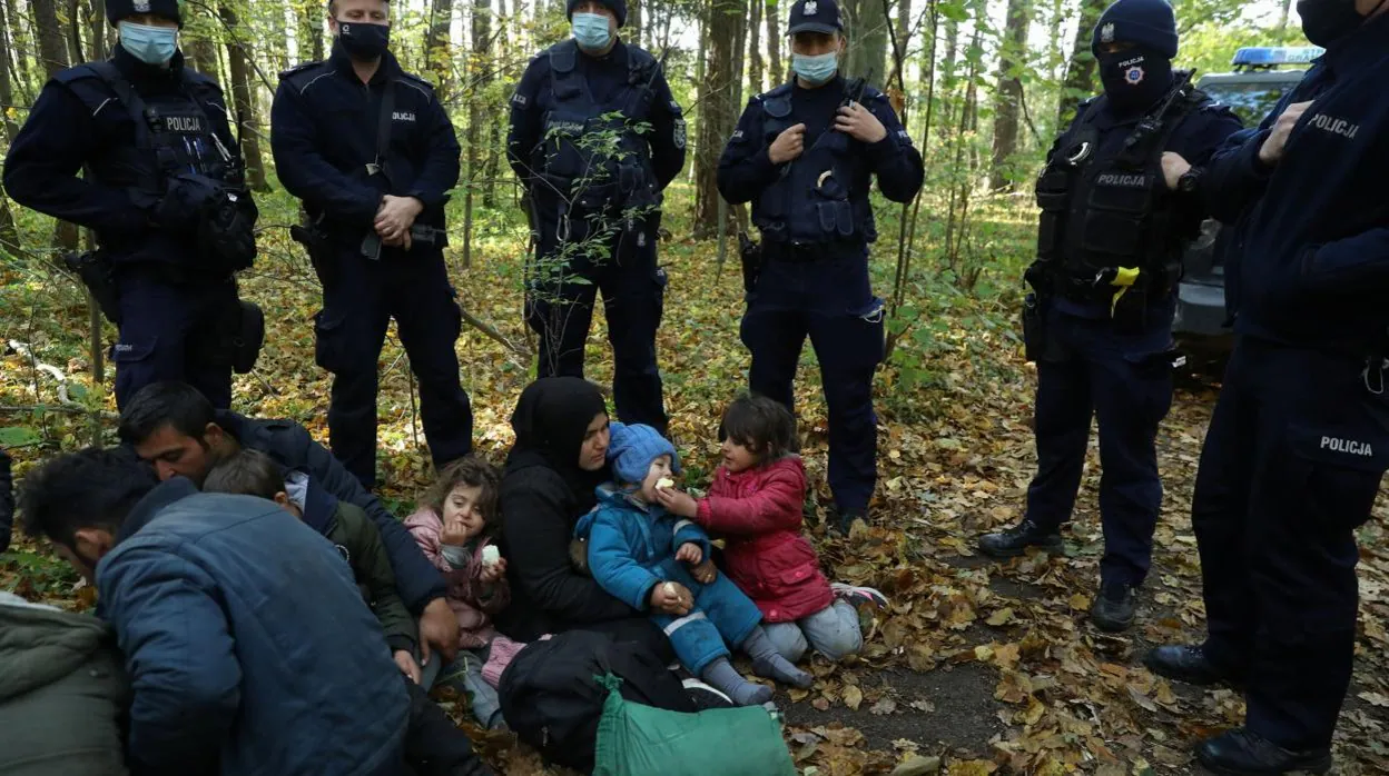 La policía supervisa a una famlia iraquí en la frontera de Polonia con Bielorrusia