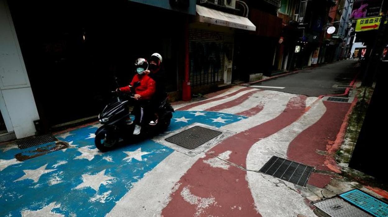 Un motorista circula sobre una bandera de EE.UU. pintada en una calle de Taipéi