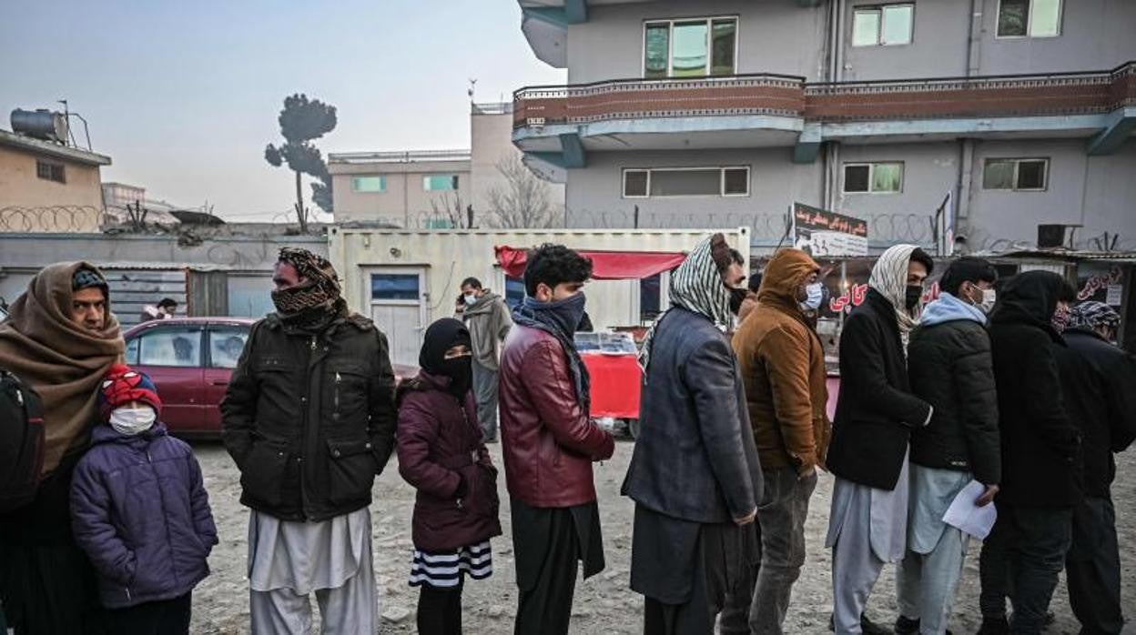 Personas hacen cola para ingresar a la oficina de pasaportes en un puesto de control en Kabul