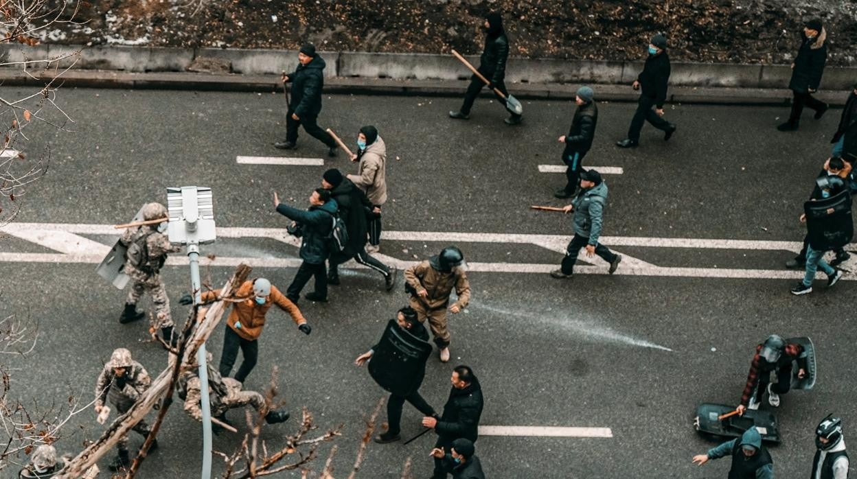 Manifestantes chocan con policías kazajos durante una manifestación por un alza en los precios de la energía en Almatí