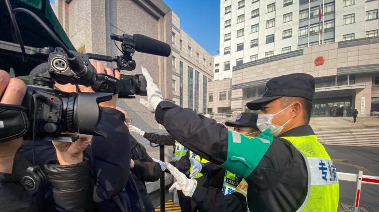 Un policía tapa una cámara de televisión en China