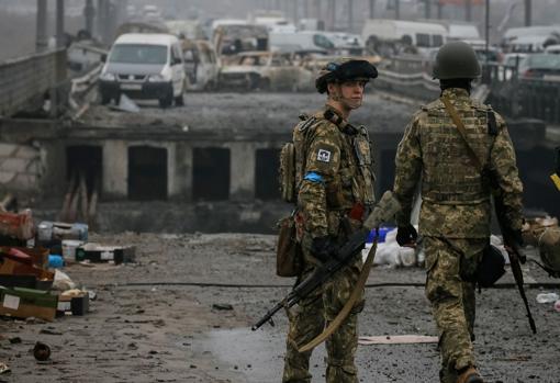 Dos militares ucranianos custodian un puente destruido, en la ciudad de Irpin