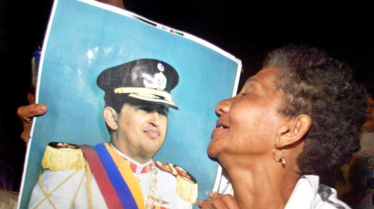 Una señora acaricia una fotografía de Hugo Chávez, dos días después del golpe fallido