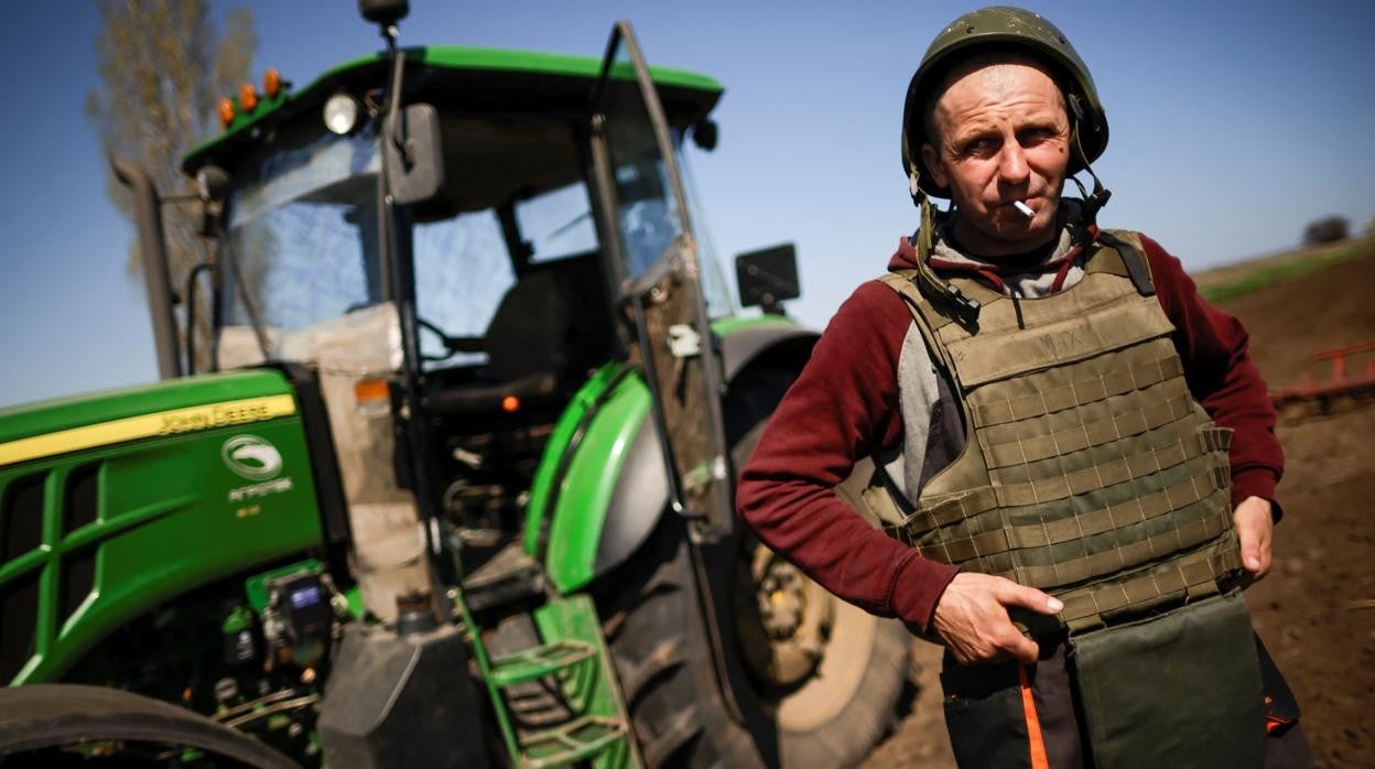 Yuri, un granjero ucraniano vestido con casco y chaleco antibalas, trabaja en la región de Zaporiyia