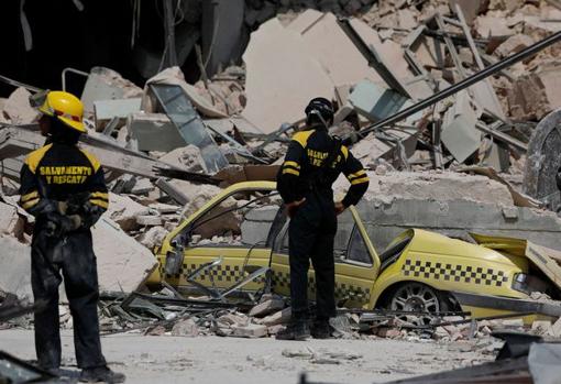 Un coche enterrado por los escombros del hotel Saratoga