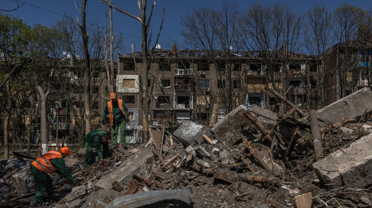 Trabajadores municipales limpian una zona dañada después de un bombardeo aéreo ruso en Kramatorsk