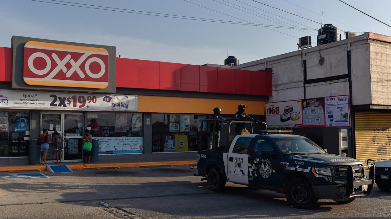 Miembros de la fuerza civil vigilan la zona donde fueron asesinadas Yesenia Mollinedo Falconi y Sheila Johana García en una tienda Oxxo