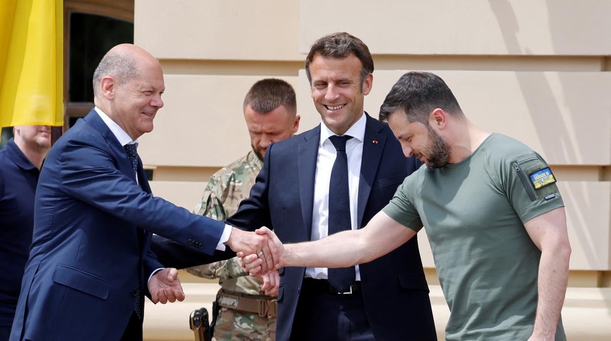 El presidente de Ucrania, Volodímir Zelenski, le da la mano al canciller alemán, Olaf Scholz, junto al presidente de Francia, Emmanuel Macron
