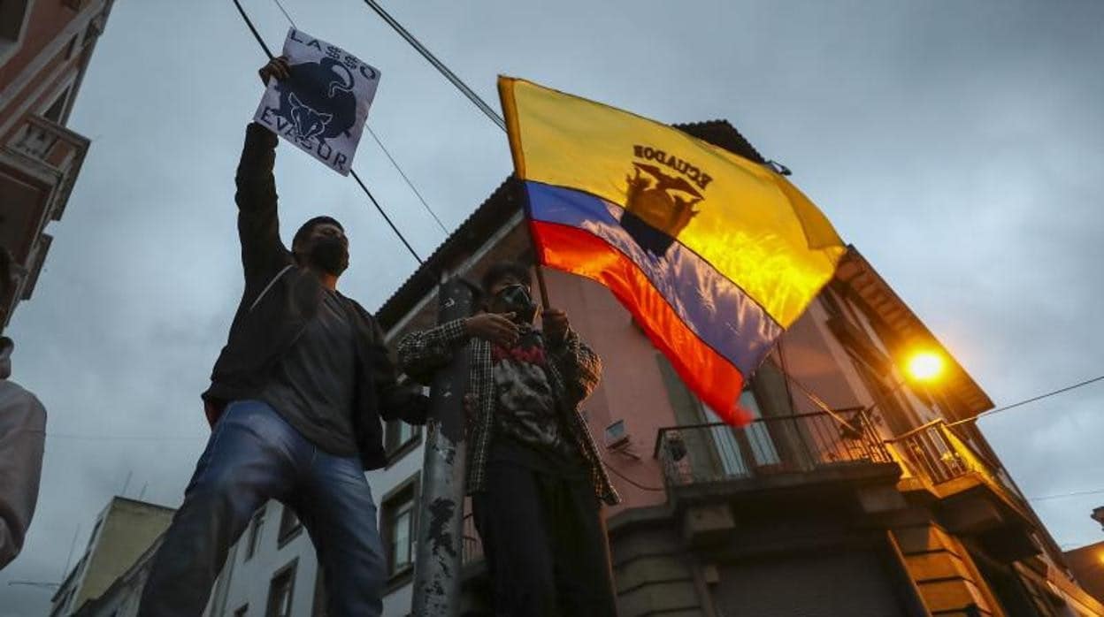 Manifestantes ondean hoy una bandera ecuatoriana durante protestas contra el Gobierno de Guillermo Lasso