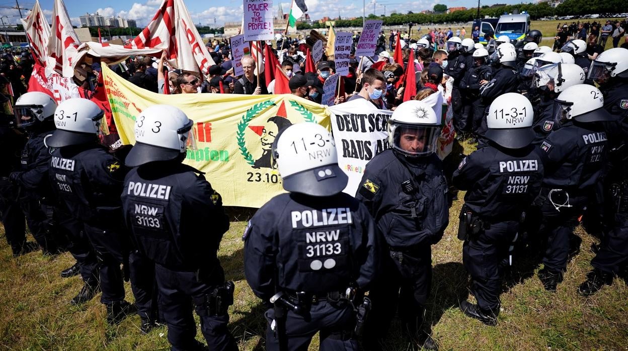 Agentes de policía alemanes vigila a unos manifestantes mientras protestan por la cumbre del G-7