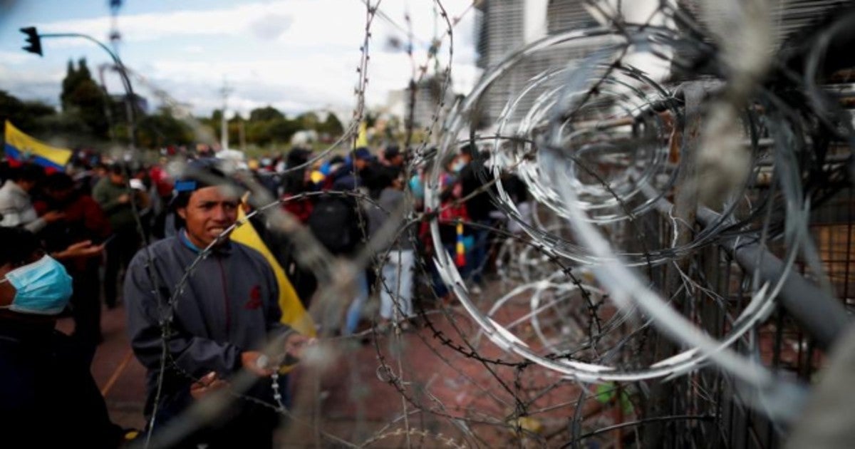 Manifestantes junto a una barricada cubierta con alambre de púas en Quito