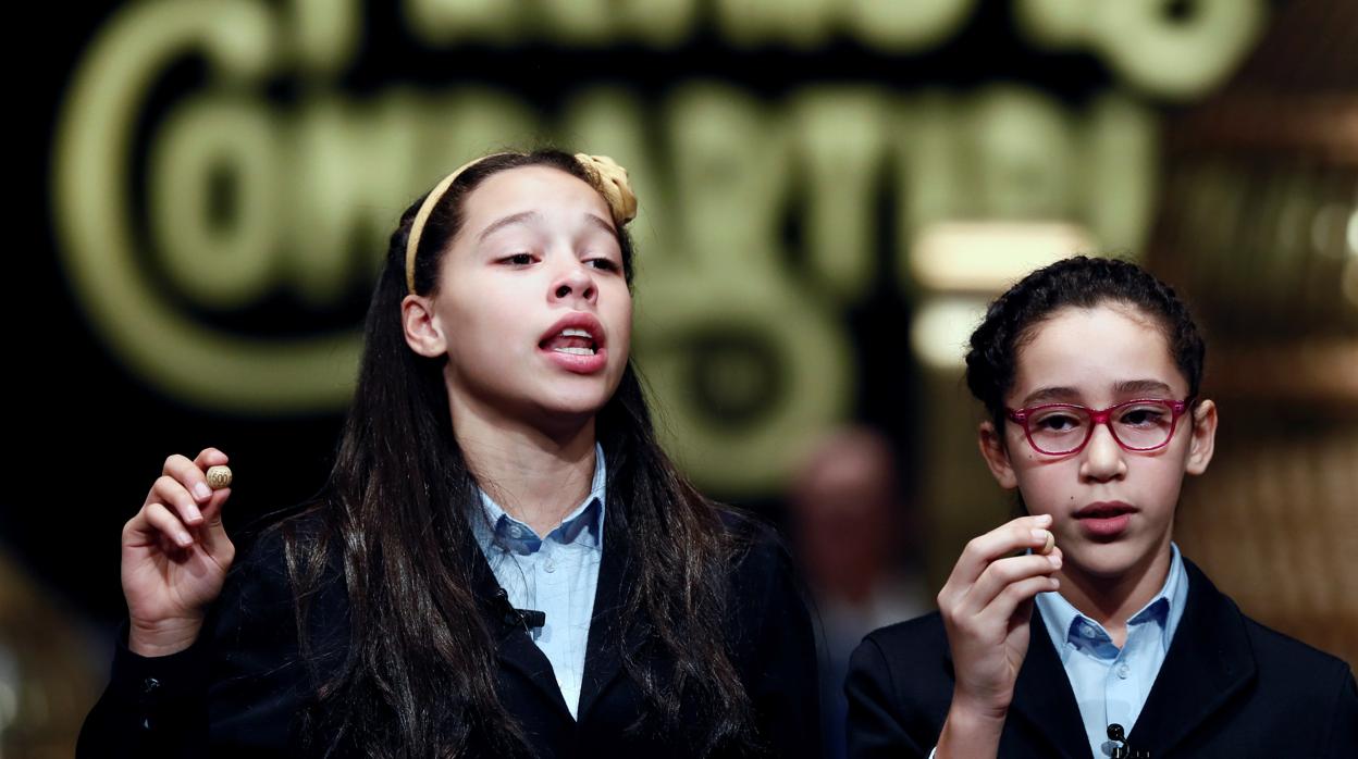 Los niños de San Ildefonso Noura Akrouh (d) y Elizabeth del Carmen Roque (i) muestran el número 04211 que ha sido agraciado con tercer premio