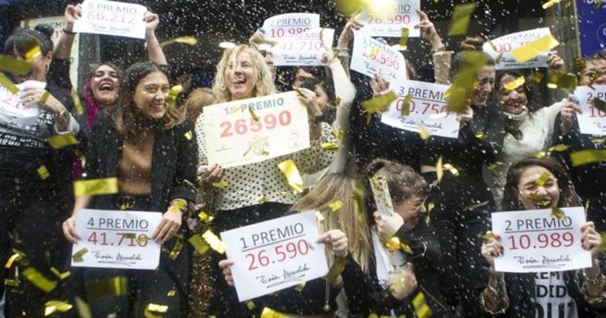 Varios afortunados celebran sus premios a las puertas de la administración de Doña Manolita, el año pasado