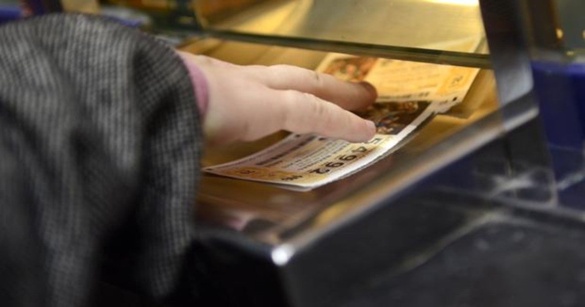 Una mujer compra un décimo de la Lotería de Navidad